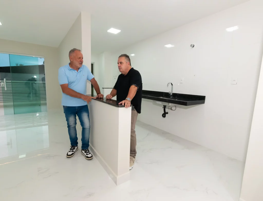 Foto mostra os sócios da CDL Construtora, Dirceu Viapiana e Luciano Ferreira na sala do apartamento modelo do empreendimento