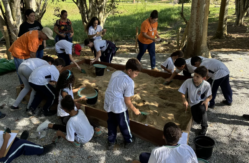 Várias crianças brincando na areia