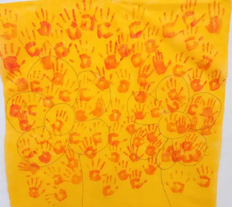 Cartaz coletivo com estampas de mãos das crianças simboliza a união 