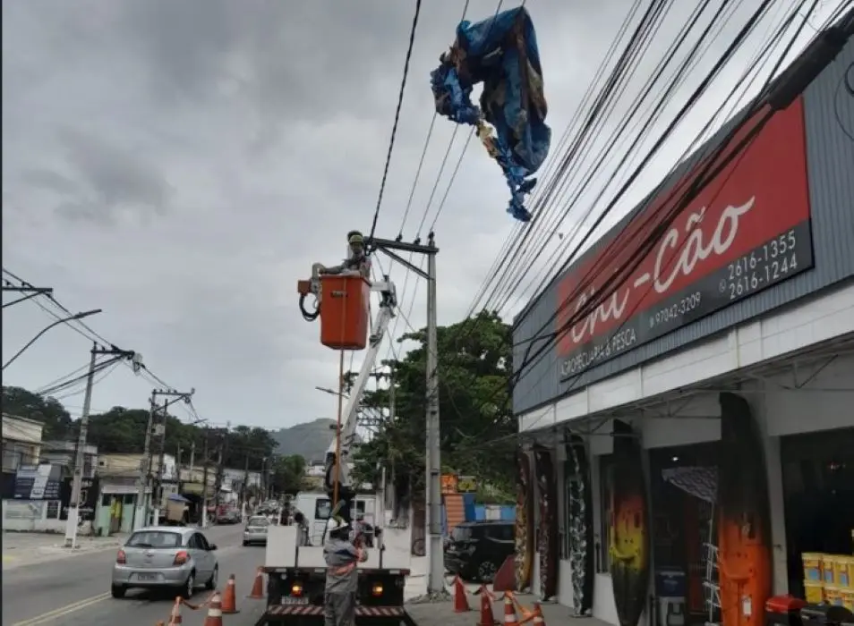 Técnicos da concessionária de energia realizam a remoção de balão preso à rede elétrica