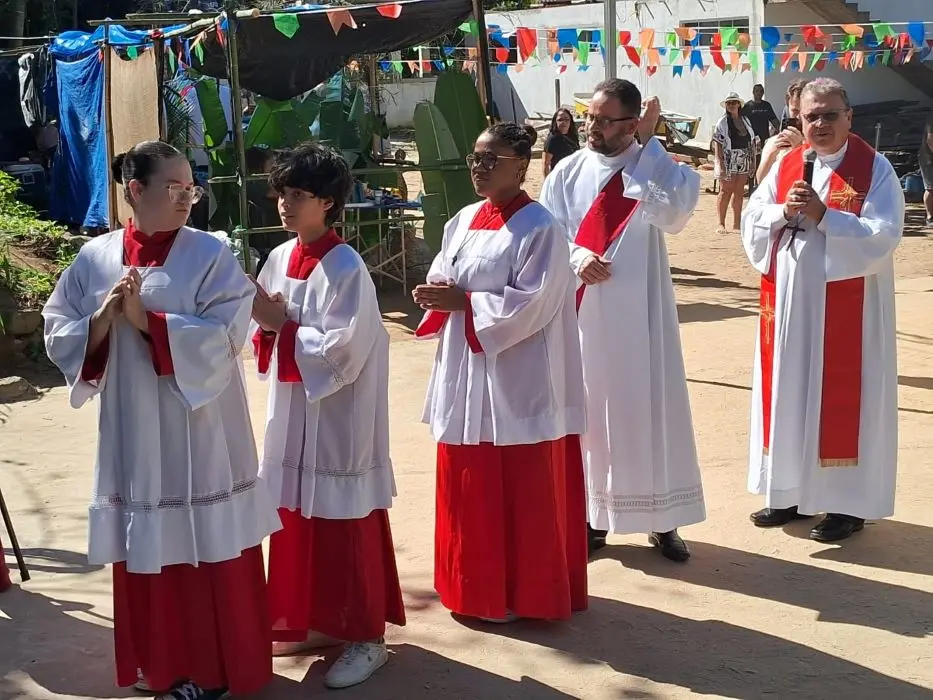 Coroinhas caminham para a igreja na frente do bispo