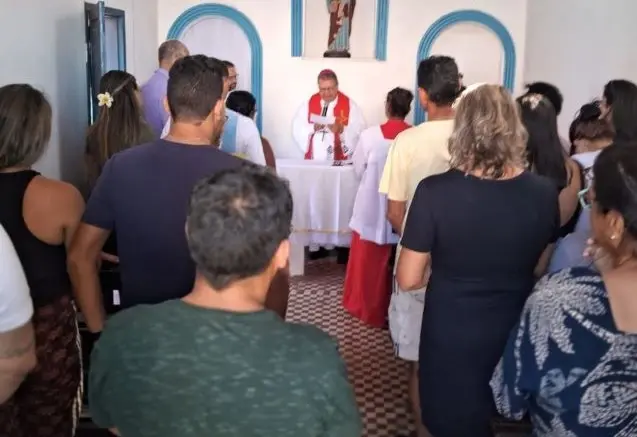 Pessoas acompanha a missa no interior da igreja