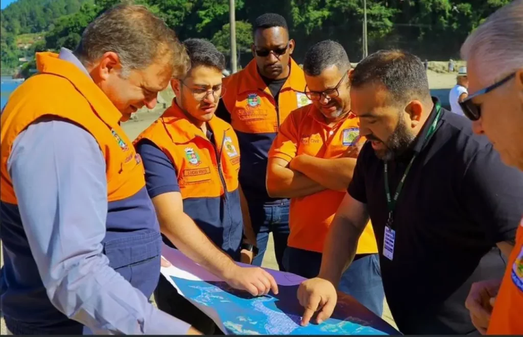 Equipes da Defesa Civil e autoridades municipais analisam mapa da região