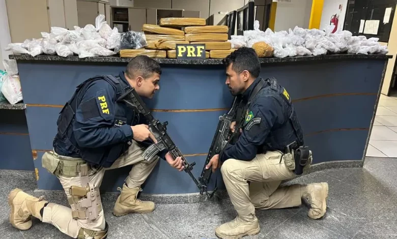 Policiais rodoviários federais exibem parte da carga de drogas e artefatos explosivos apreendidos