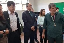 Três pessoas ouvindo explicações do professor