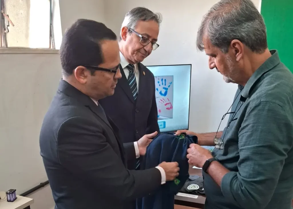 Três homens olhando uma roupa