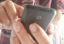 Cidadão manipulando um telefone celular
