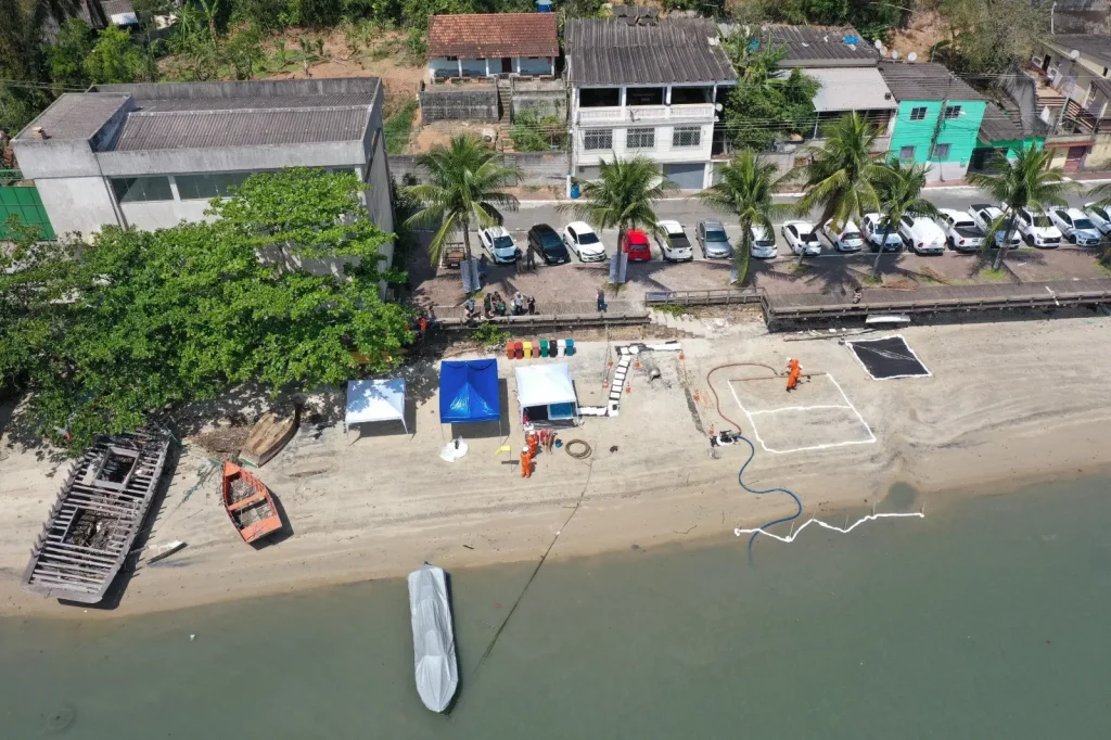 Imagem do alto mostrando homens trabalhando na praia