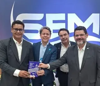 Quatro homens segurando e exibindo juntos o livro lançado no evento