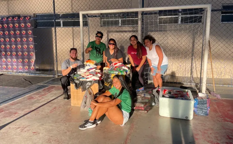 Equipe organizadora do evento posa com os alimentos arrecadados