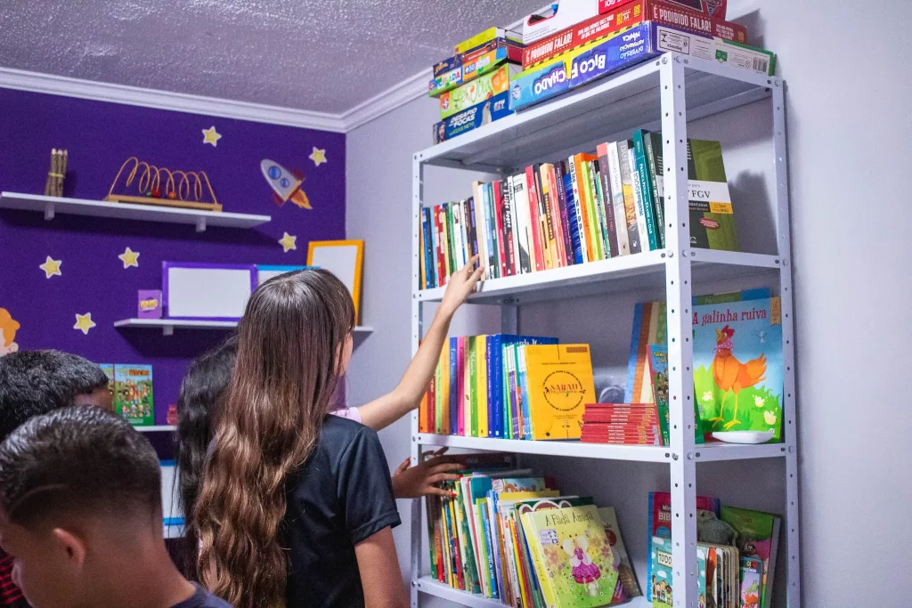 Crianças observando uma prateleira de livros