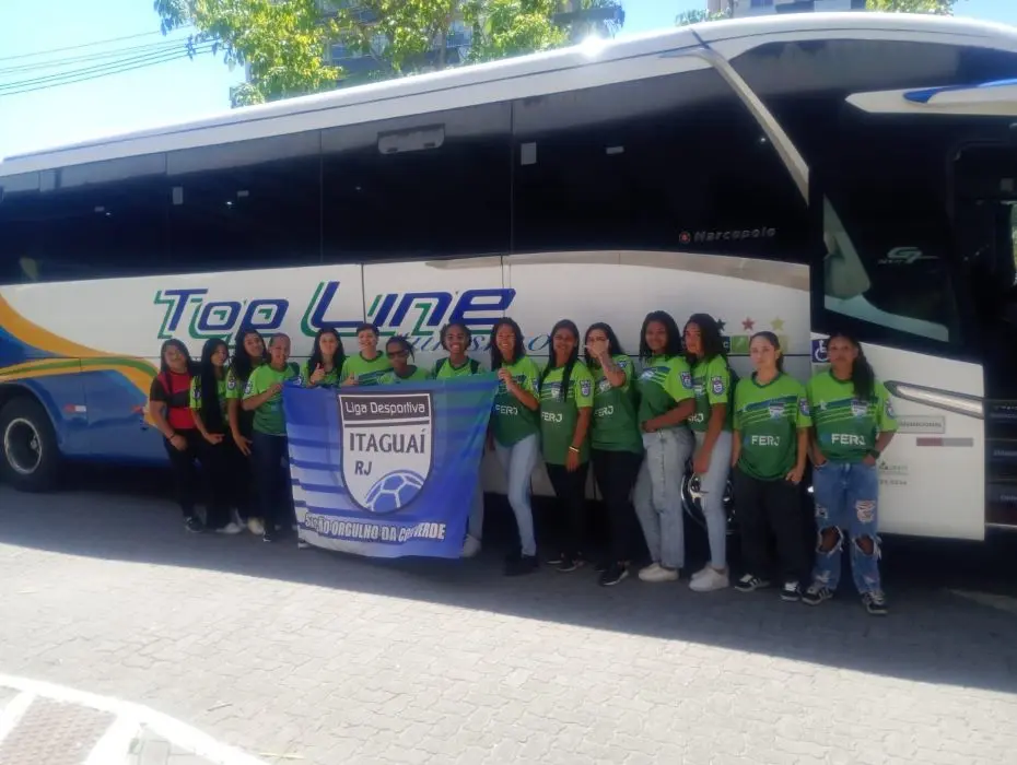 Meninas de Itaguaí posam ao lado do ônibus antes de entrar em campo