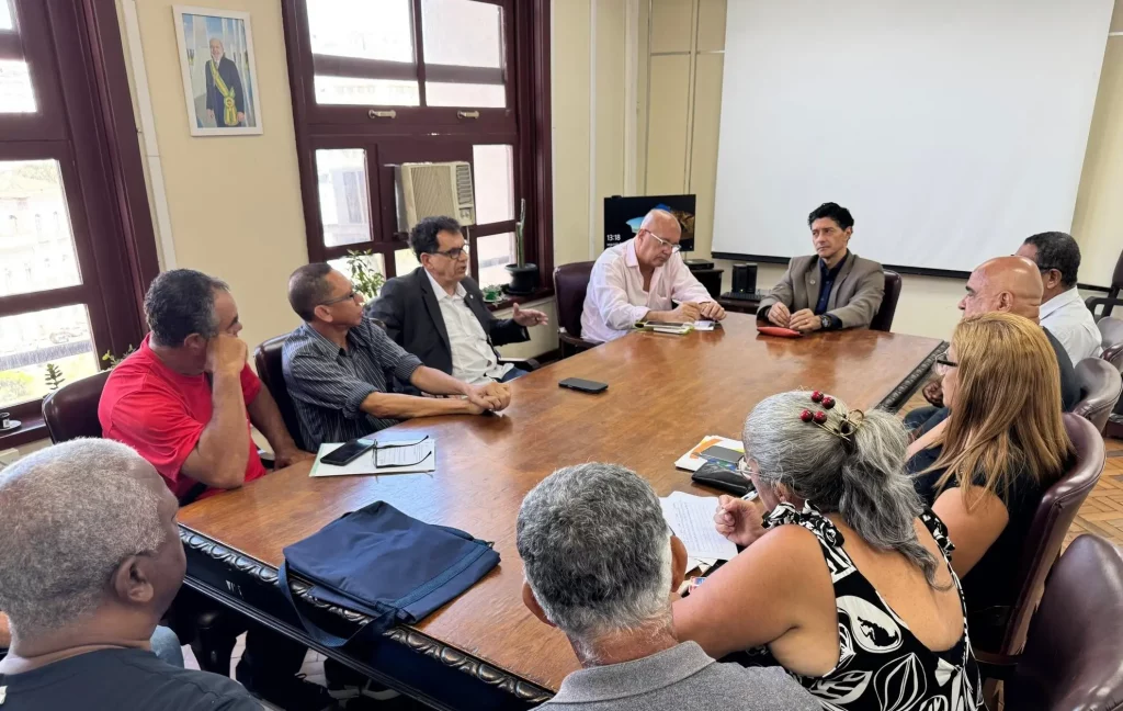 Várias pessoas sentadas à mesa numa reunião