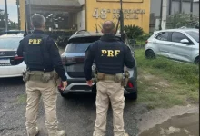 Policiais rodoviários federais apresentam o veículo recuperado