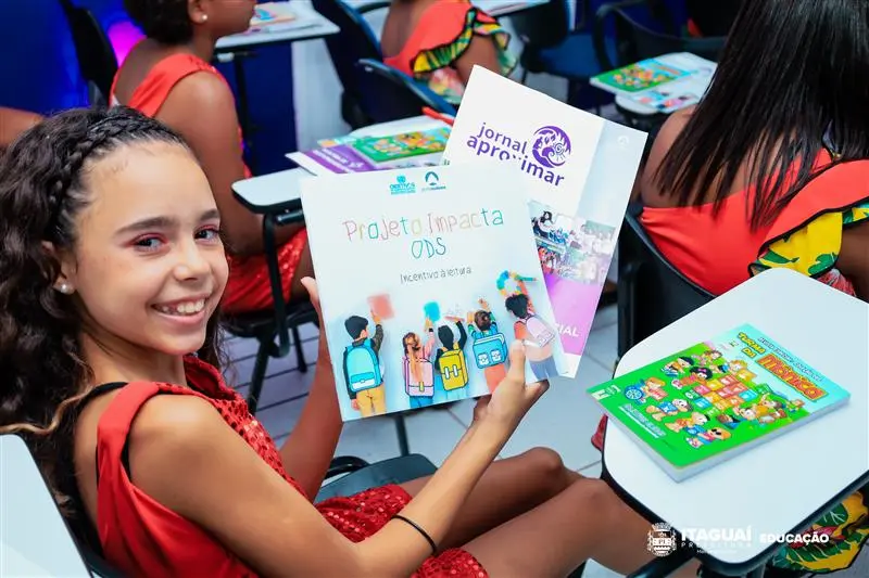Menina sorridente posando para foto com livro