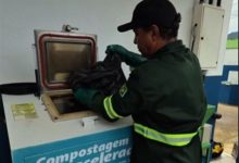Funcionário realiza o descarte de resíduos orgânicos na máquina de compostagem
