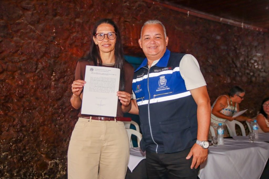 O secretário de Educação, Renato Delmiro, realiza a entrega do termo de posse a nova servidora
